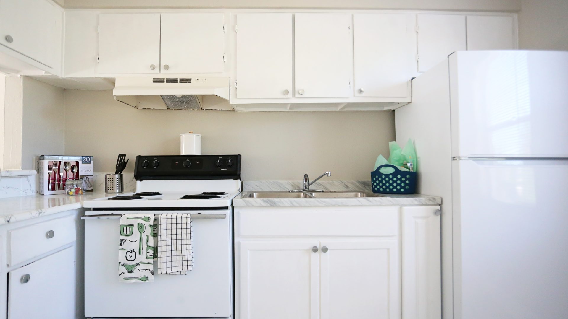 a white kitchen with a stove, refrigerator and microwave at The Vista Villa Apartments