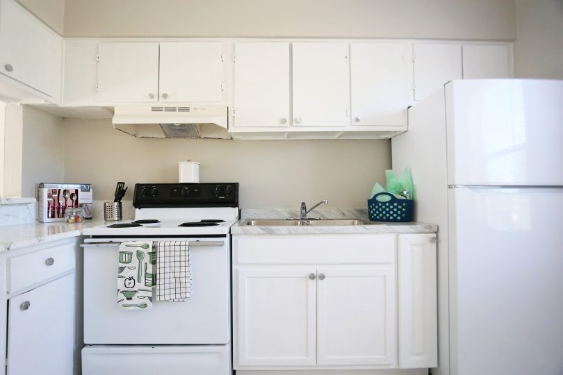 a white kitchen with a stove, refrigerator and microwave at The Vista Villa Apartments